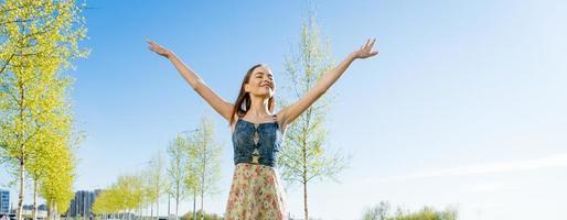 attraktiv Lycklig ung kvinna lång blommig klänning flygande henne hår njuter fri foto