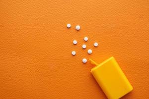 artificiell sötningsmedel behållare på orange bakgrund foto