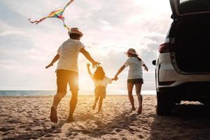 Lycklig familj med bil resa väg resa. sommar semester i bil i de solnedgång, pappa, mamma och dotter Lycklig reser njut av tillsammans körning i högtider, människor livsstil rida förbi bil. foto