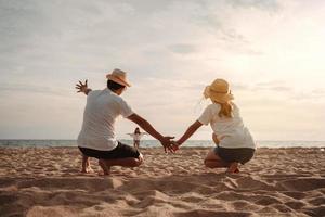 Lycklig asiatisk familj njut av de hav strand på bestående far, mor och dotter har roligt spelar strand i sommar semester på de hav strand. Lycklig familj med semester tid livsstil begrepp. foto