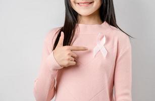 Lycklig kvinna som visar rosa band, bröst cancer medvetenhet, värld cancer dag, nationell cancer efterlevande dag i februari begrepp. foto