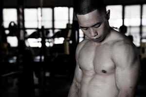 sexig kropp av muskulös ung soldat asiatisk man i Gym. begrepp av hälsa vård, övning kondition, stark muskel massa, kropp förbättring, fett minskning för herr- hälsa tillägg produkt presentation. foto