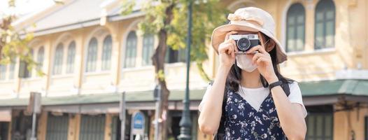 resande, resa asiatisk ung kvinna eller flicka använda sig av kamera ta Foto, gammal stad gata, stad turism på Lycklig solig dag. backpacker turist, Semester resa, sommar eller semester, hobby begrepp. foto