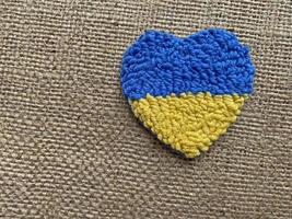 hjärta med flagga av ukraina mot brun duk foto