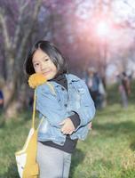 Lycklig resande flicka leende på körsbär blomma bakgrund, foto