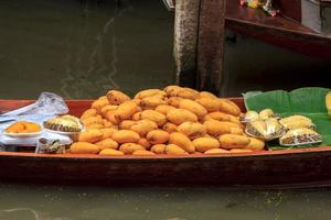 båtar försäljning frukt - mogen mango - i damnoen saduak flytande marknadsföra är en populär turist destination den där européer och kinesisk tycka om till resa med de traditionell sätt av liv av de bybor. foto