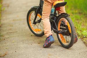 pojke med en cykel på de gata. hjul av en barns cykel foto