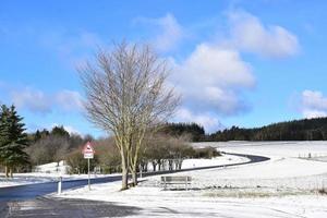 solig väg med sent Mars snö i de eifel foto