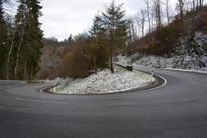 mörk serpentin med sent Mars snö i de eifel foto