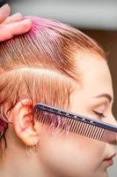 frisör gör kort rosa frisyr foto