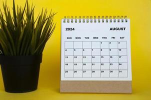 augusti 2024 månad kalender med tabell växt på gul omslag bakgrund. en gång i månaden kalender begrepp foto