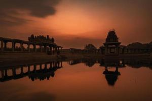 solnedgång på pushkarani sjö nära vijaya vitthala tempel i hampi foto