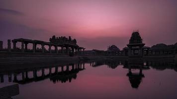 solnedgång på pushkarani sjö nära vijaya vitthala tempel i hampi foto