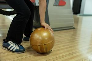 ung flicka har roligt med boll i bowling klubb. foto