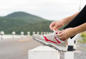 kvinna kvitt skosnöre hans innan startande löpning foto