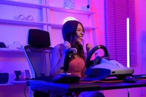 ung asiatisk Söt kvinna proffs gamer ha leva strömning spelar video spel, tävlings spel på Hem foto
