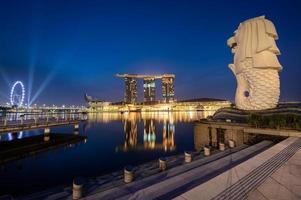 singapore 27.12.2565 merlion fontän i främre av de marina bukt sandstrand hotell på natt . merlion är känd plats som en symbol av singapore foto
