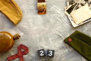 flaska, keps, soldat bälte med en femspetsig stjärna med en hammare och skära och gammal fotografier en trä- kalender februari 23 . fädernesland försvarare dag. foto