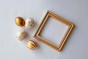 påsk ägg på en guld och trä- ram bakgrund på en vit bakgrund. foto