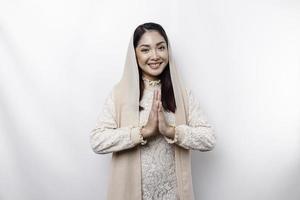 porträtt av en ung skön asiatisk muslim kvinna bär en slöja gestikulerar eid mubarak hälsning foto