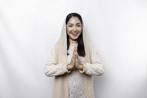 porträtt av en ung skön asiatisk muslim kvinna bär en slöja gestikulerar eid mubarak hälsning foto