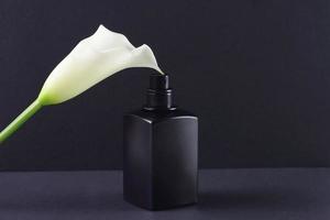 svart parfym flaska och vit lilja blomma, attrapp foto