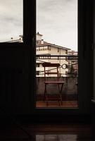 trä- stol på de fönster av en rum med en se av de stad. foto