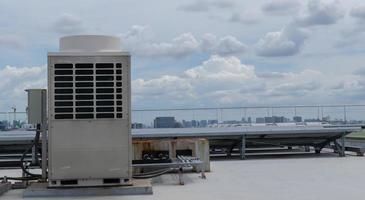 luft balsam enheter hvac på en tak av industriell byggnad med blå himmel. foto