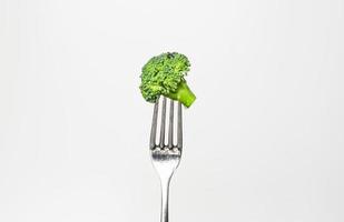 färsk broccoli på gaffel isolerat på vit. friska livsstil begrepp foto