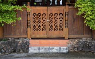 främre se av ingång trä ristade dörr, thai stil foto