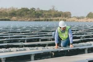 ingenjör inspektör innehav bärbar dator och arbetssätt i sol- paneler kraft växt kontroll solceller celler och elektricitet produktion. foto