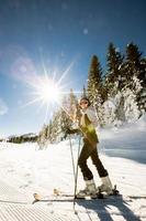 ung kvinna enjoing vinter- dag av skidåkning roligt i de snö foto