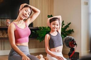 erfarenhet de glädje av familj yoga med ett asiatisk lärare och flickans virtuell klass foto