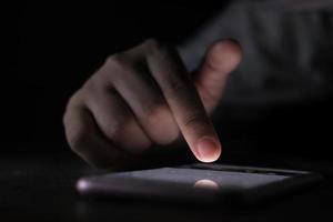 närbild av kvinnors hand med smart telefon på natten foto
