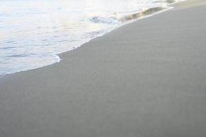 suddig våg av havet på kvällen sandstranden foto