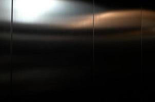 rostfri stål stor ark med ljus slå de yta, inuti passagerare hiss, reflektion av ljus på en skinande metall konsistens, rostfritt stål bakgrund, metall textur bakgrund. foto