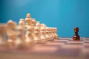 brun schackpjäs stående i främre av vit schack, begrepp av en ny börja måste ha mod och utmaning i de konkurrens, ledarskap och företag syn för en vinna i företag spel foto