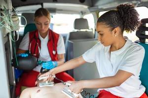 para använder sig av defibrillator i ledande en grundläggande kardiopulmonell återupplivning. nödsituation vård assistent sätta silikon manuell återupplivningsanordningar i ett ambulans. foto