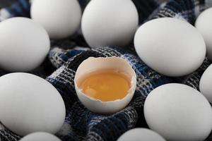 äggula och vita ägg på en randig trasa foto