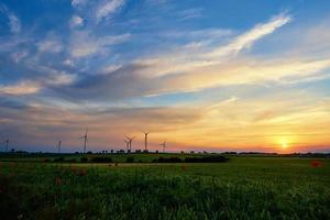 väderkvarn turbiner på solnedgång, vind energi begrepp foto