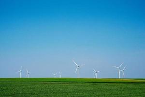 väderkvarn turbiner i grön fält, vind energi begrepp foto