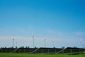 väderkvarn turbiner och sol- batteri paneler i grön fält, hållbar energi foto