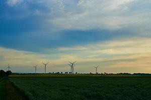 väderkvarn turbiner på solnedgång, vind energi begrepp foto