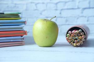 tillbaka till skolan koncept med äpple och pennor på bordet foto