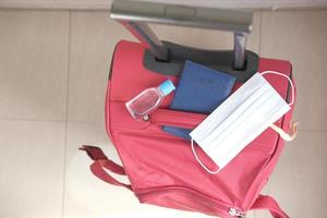 resväska med mask, pass och handdesinfektionsmedel