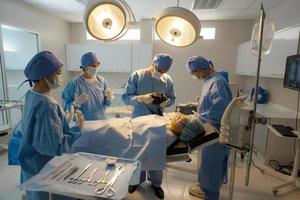 läkare, sjuksköterska håller på med kirurgi på patient. foto