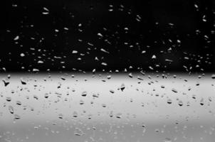 vatten droppar på glas textur abstrakt svart mörk bakgrund, selektiv fokus foto