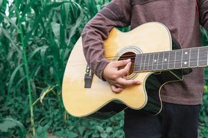 pojke som spelar en gitarrnärbild foto