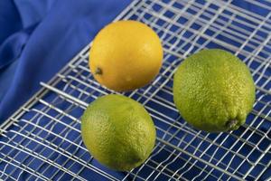gula och gröna citroner på en duk foto