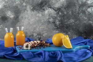 två glasskannor med utsökt juice och skivad orange frukt foto